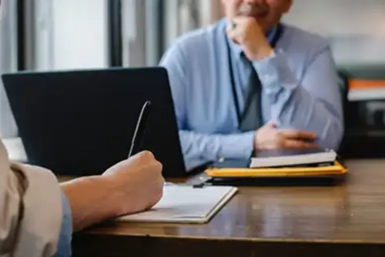 Office worker is interviewed while the another takes notes